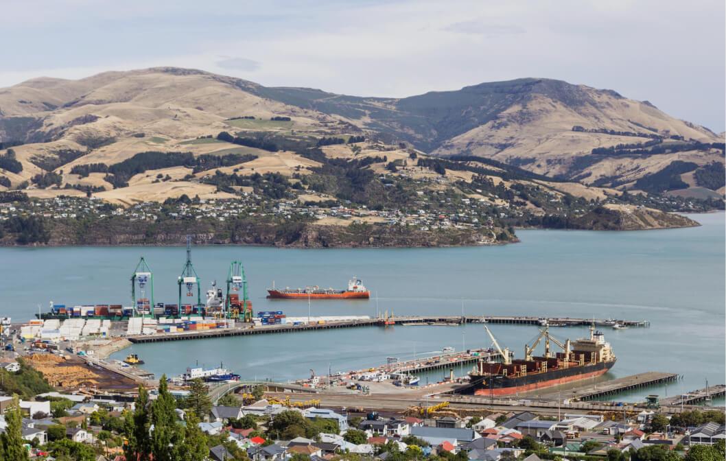 Container port and shipping vessel in Lyttelton harbor near the city of Christchurch and the Banks peninsula in New Zealand south island.